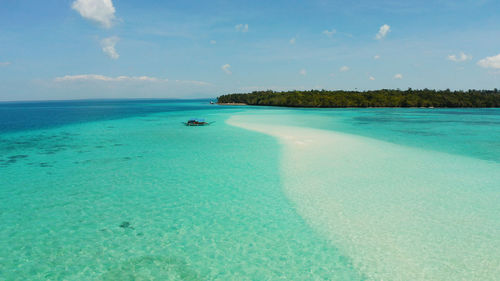 Beautiful beach in the blue water and an island with coral reef. mansalangan sandbar