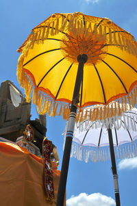 Low angle view of two typical balinese umbrellas placed in front of a small shrinein ubud, bali