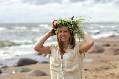 Portrait of smiling young woman standing on beach