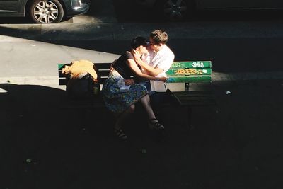 High angle view of man sitting on mobile phone