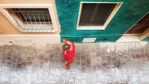 Woman with red umbrella on building