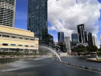 View of city buildings against cloudy sky