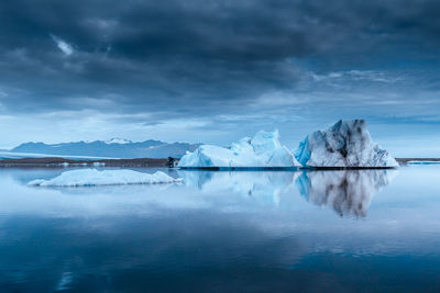 Scenic view of lake against cloudy sky