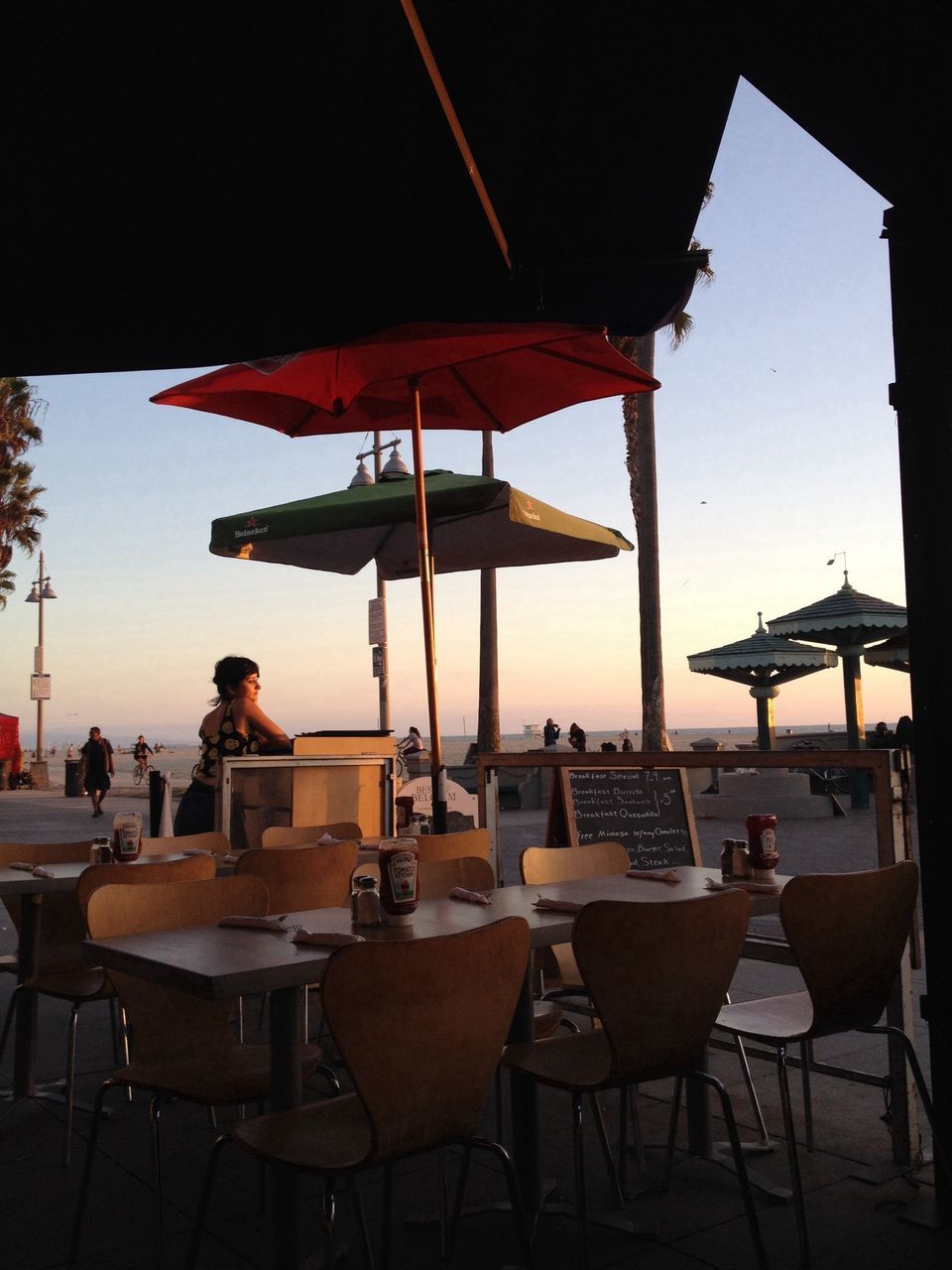 chair, table, restaurant, sea, absence, parasol, sunshade, built structure, empty, sky, water, sunlight, architecture, beach, horizon over water, beach umbrella, clear sky, seat, lounge chair, sidewalk cafe