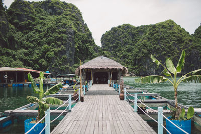 Gazebo on pier in lake against mountains