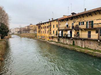 River flowing amidst buildings against sky