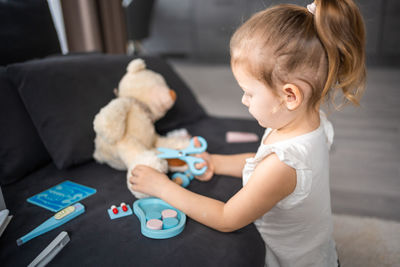 Side view of cute girl with teddy bear