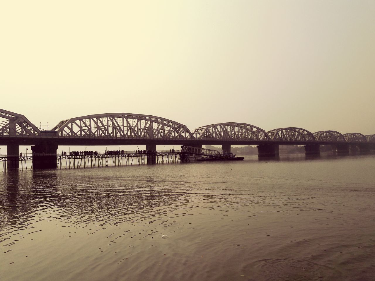 built structure, clear sky, architecture, connection, water, bridge - man made structure, copy space, bridge, river, engineering, sea, waterfront, travel destinations, tranquility, beach, tranquil scene, arch, long, outdoors, pier