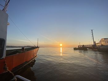 Sailboats in sea against sky during sunset