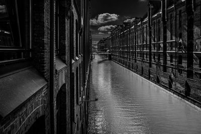 Bridge over river amidst buildings against sky