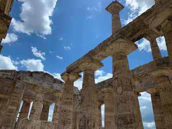 Low angle view of old ruin building against cloudy sky