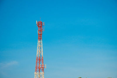 Low angle view of communications tower against blue sky