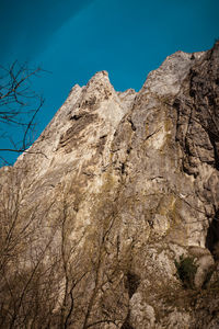 Low angle view of rock formations against clear blue sky