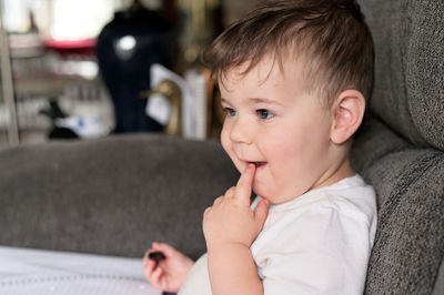 Portraint of an expressive young toddler on the couch at home