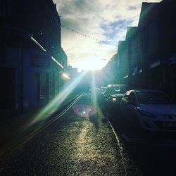 Sun shining through buildings in city