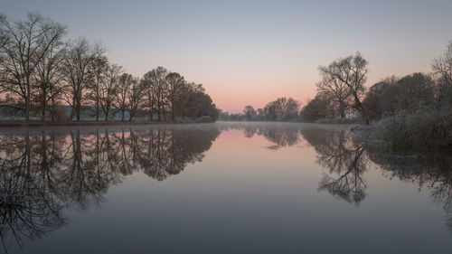 Scenic view of lake against sky at sunset