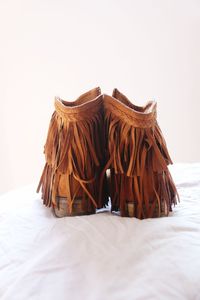 Close-up of leather cowboy boots on bed 