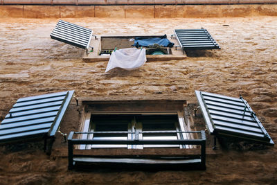 Open shutters of windows on an old stone wall. bottom view. 