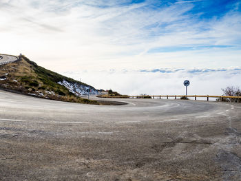 Road by mountain against sky