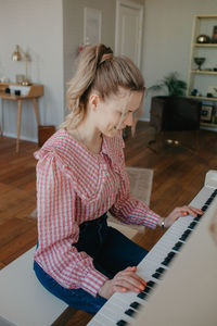 Young beautiful woman playing the piano. high quality photo