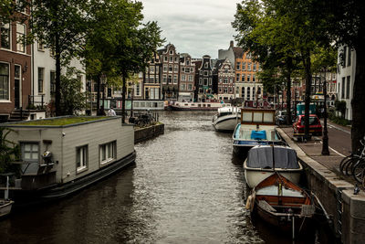 Boats in canal amidst buildings in city