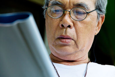 Close-up of senior man using digital tablet