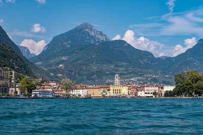 Buildings by sea against sky