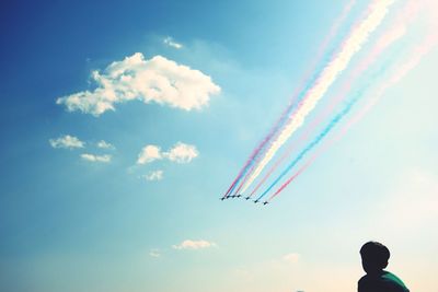 Low angle view of airplanes with colorful trails in flight