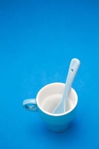 Close-up of white bowl over blue background