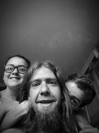 High angle portrait of smiling mature man with daughters against ceiling at home