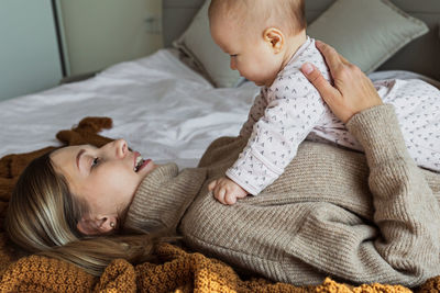 High angle view of cute baby girl lying on bed at home