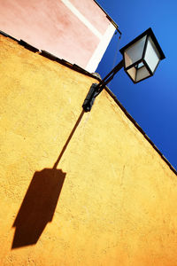 Low angle view of lantern on building against clear blue sky