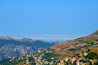 Scenic view of mountains against blue sky