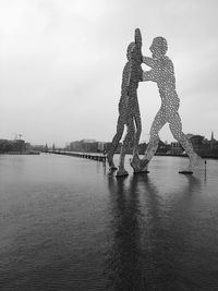 Bridge over river against sky in city