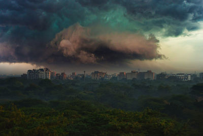 Panoramic view of buildings in city against cloudy sky