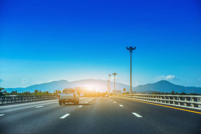 Cars on road against blue sky