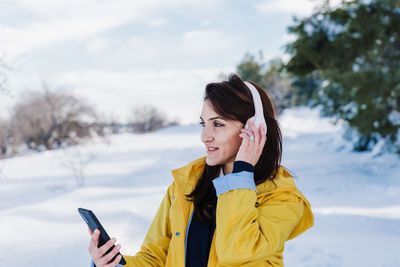 Young woman using mobile phone in winter