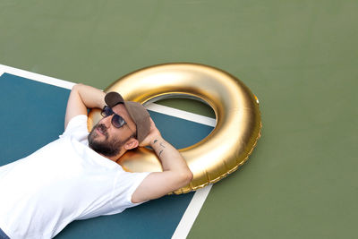 High angle view of lying on inflatable ring on court