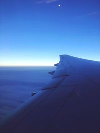 Airplane flying over sea against clear blue sky