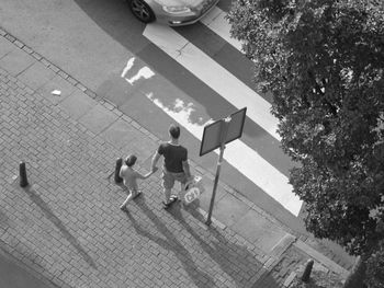 High angle view of man and son walking on street