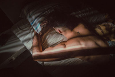 Close-up of man sleeping on bed at home