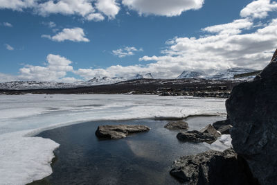 Scenic view of lake against sky during winter