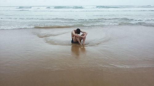 Young man sitting on beach