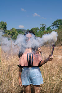 Woman holding distress flare on land