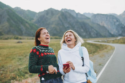 Happy woman standing against mountain