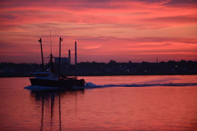 Boat sailing on sea against sky during sunset