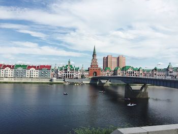 Bridge over river in city against sky