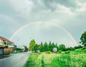 Scenic view of rainbow against sky during rainy season
