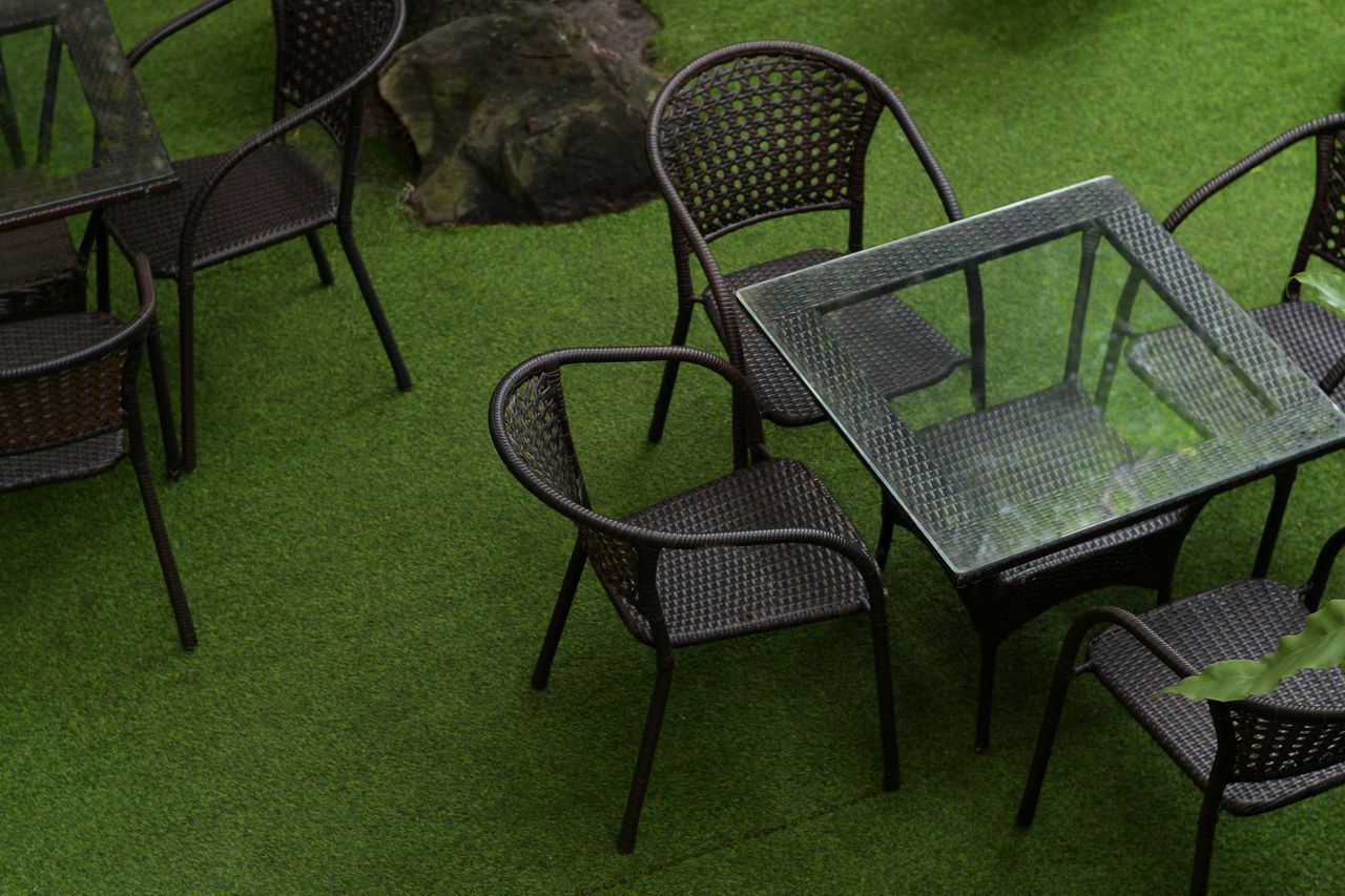 HIGH ANGLE VIEW OF EMPTY CHAIRS AND TABLE IN FIELD