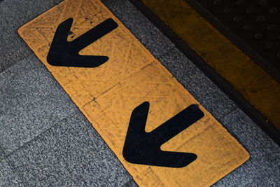 High angle view of arrow symbols on footpath